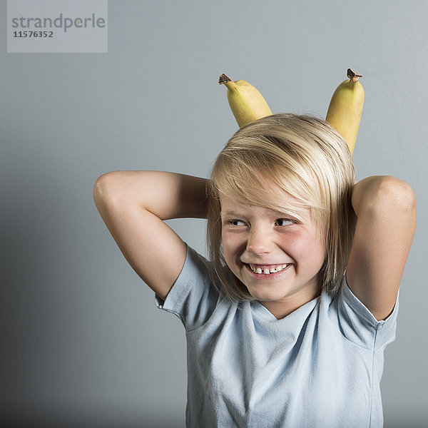 Bildnis eines Jungen mit Händen hinter dem Kopf  der Bananen hält