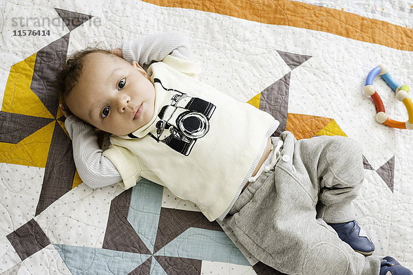 Porträt eines auf einer Decke liegenden Jungen  Draufsicht