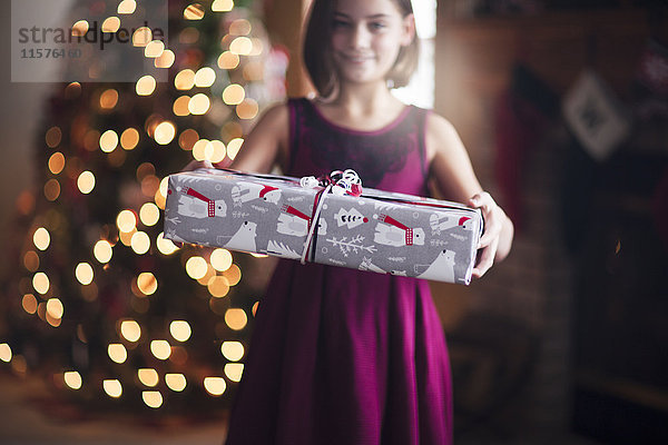 Junges Mädchen hält Weihnachtsgeschenk