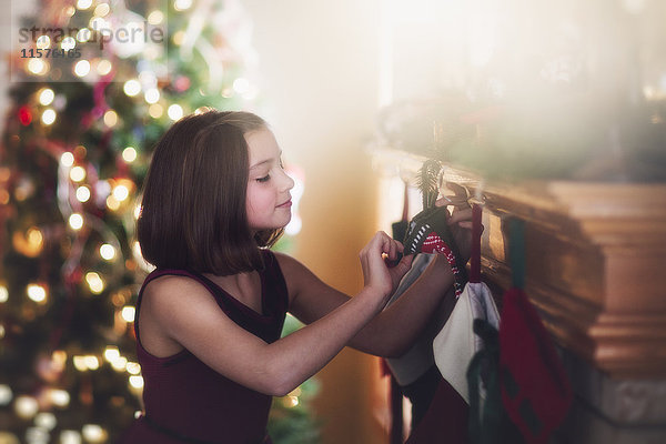 Junges Mädchen betrachtet Weihnachtsstrumpf