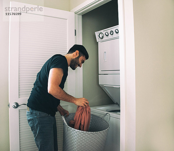 Mann beim Wäschewaschen zu Hause