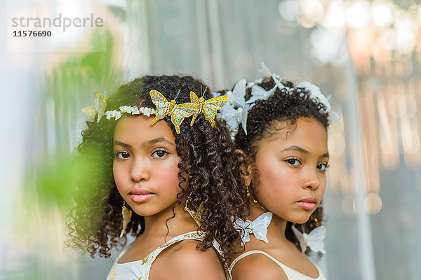 Porträt von zwei Mädchen  die Schmetterlinge im Haar tragen