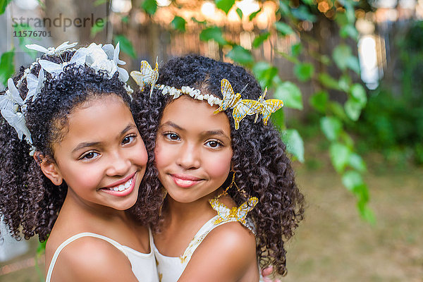 Porträt von zwei Mädchen  die Schmetterlinge im Haar tragen