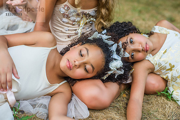 Gruppe junger Mädchen  als Feen verkleidet  auf Gras liegend