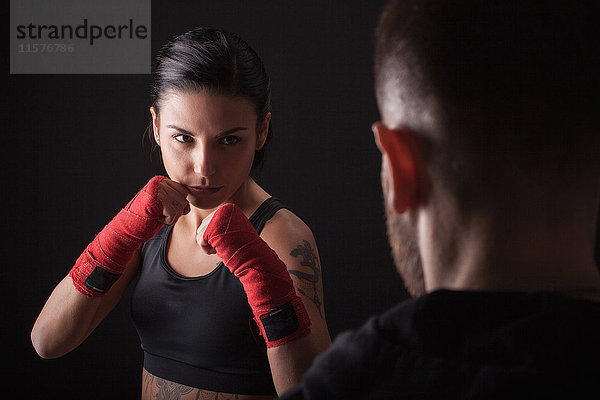 Porträt einer jungen Frau in Kampfhaltung  vor Fitnesstrainerin