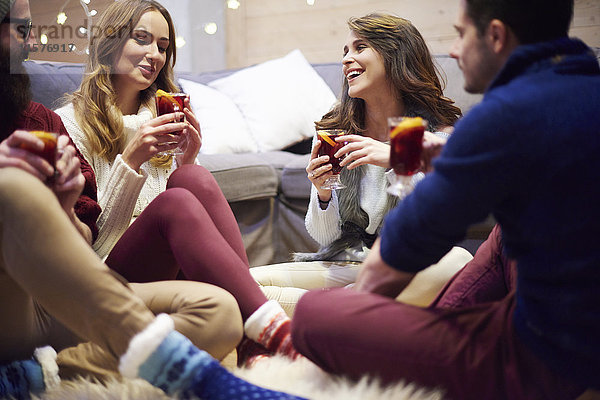 Freunde genießen Glühwein im Chalet