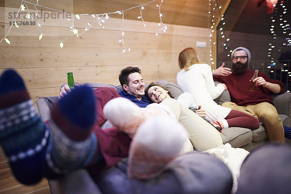 Freunde genießen das Zusammensein auf dem Sofa im Chalet