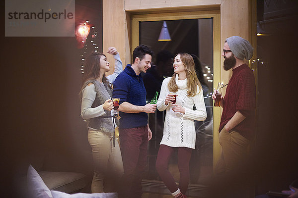 Freunde genießen Glühwein im Chalet