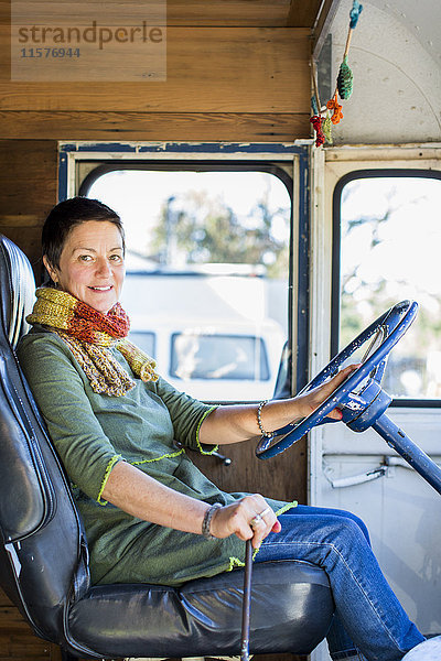 Porträt einer reifen Hippie-Frau auf dem Fahrersitz eines Wohnmobils