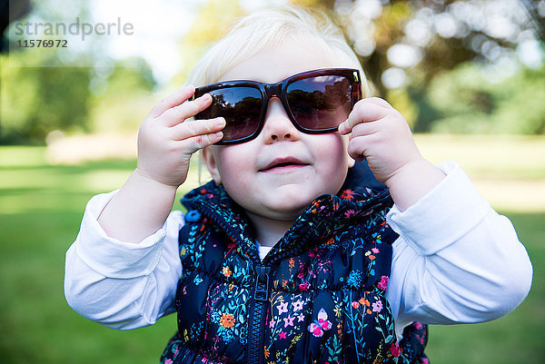 Porträt des Kleinkindes mit Sonnenbrille im Park