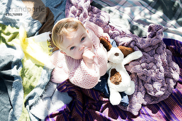 Overhead-Porträt eines kleinen Mädchens  das von der Decke im Garten aufschaut.