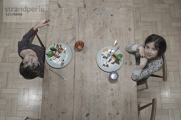Porträt der Schwester und des Bruders beim Abendessen am Küchentisch