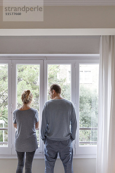 Mittleres erwachsenes Paar zu Hause  Blick aus dem Fenster  Rückansicht
