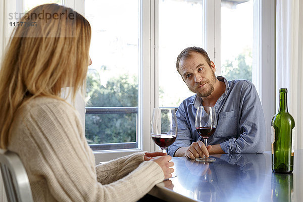 Mittleres erwachsenes Paar zu Hause  trinkt ein Glas Wein  hat Meinungsverschiedenheiten