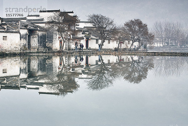 Spiegelbild von kahlen Bäumen und traditionellen Häusern am See  Hongcun Village  Provinz Anhui  China