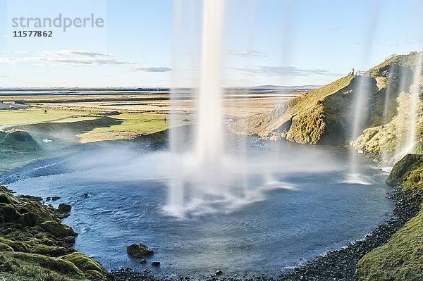 Hinter dem fliessenden Wasserfall Seljalandsfoss  Island