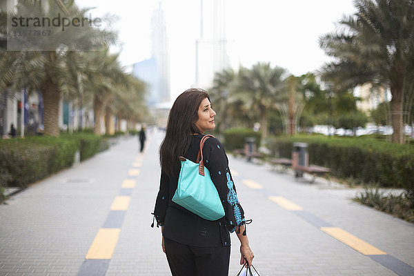 Rückansicht einer reifen Käuferin mit Einkaufstaschen  Dubai  Vereinigte Arabische Emirate