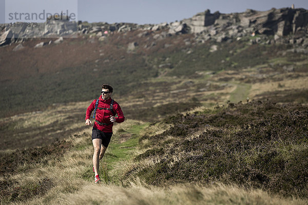Männlicher Läufer läuft in der Nähe von Stanage Edge  Peak District  Derbyshire  UK