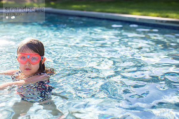 Porträt eines Mädchens mit rosa Schwimmbrille im Freibad