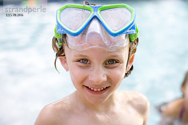 Bildnis eines Jungen mit Schwimmbrille auf dem Kopf im Freibad