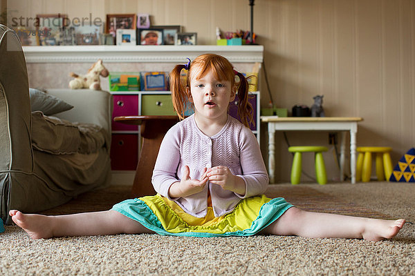 Bildnis eines jungen Mädchens mit roten Haaren  auf Teppich sitzend  Beine ausgestreckt