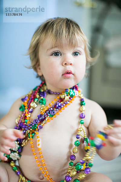 Weibliches Kleinkind probiert Perlenketten in der Küche an