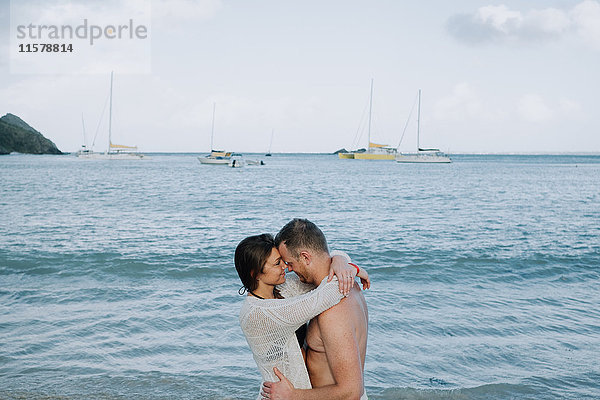 Paar steht am Meer  umarmt sich  von Angesicht zu Angesicht  St. Martin  Karibik