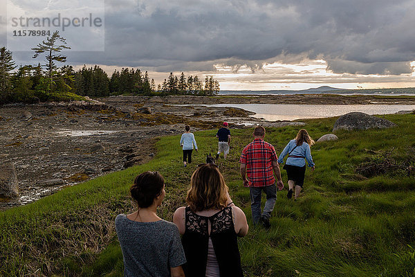 Rückansicht einer erwachsenen Familie zu Fuß zur Küste in Maine  USA