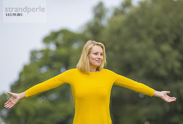 Inhalt blonde Frau im Park mit weit geöffneten Armen