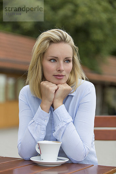 Nachdenkliche blonde Frau in einem Cafe