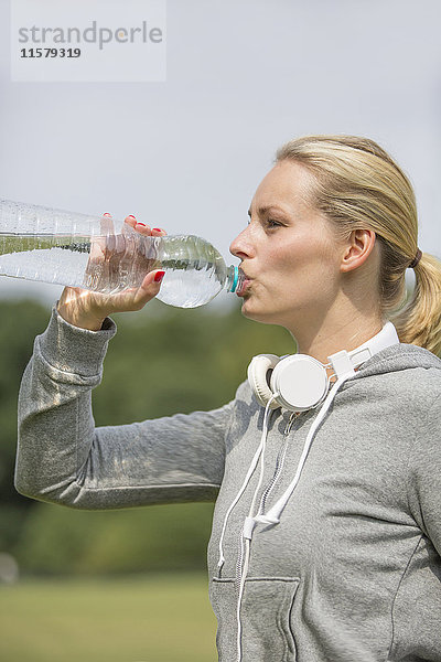 Hübsche Frau beim Sport im Park Trinkwasser