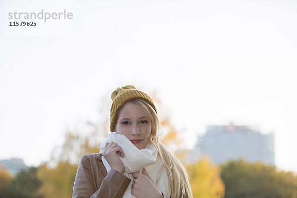 Porträt einer hübschen blonden Frau mit Mütze und Schal im Herbst