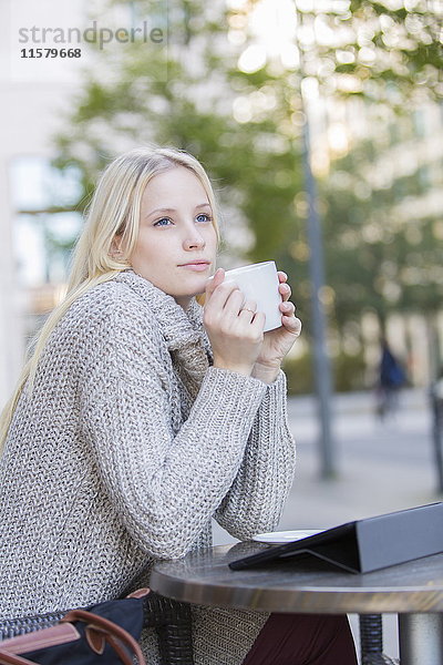 Porträt einer nachdenklichen Frau bei einem Kaffee in der Innenstadt