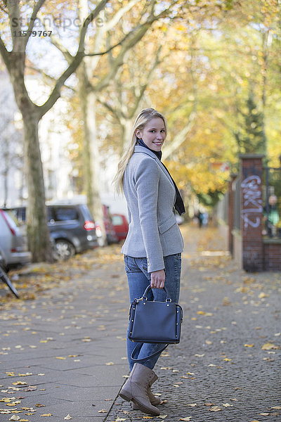 Hübsche elegante Frau mit Handtasche im Stadtzentrum