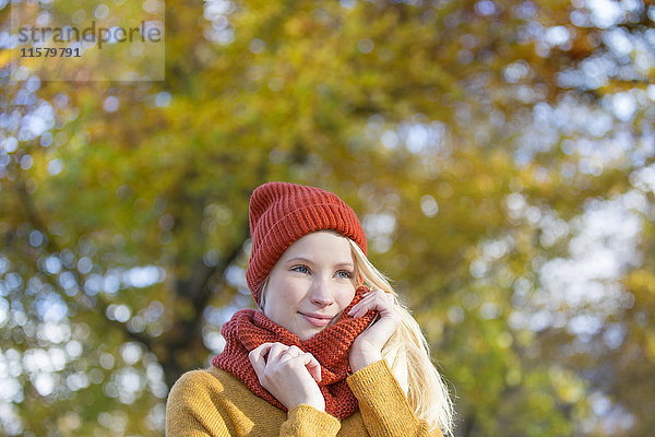 Porträt einer hübschen blonden Frau im Park im Herbst