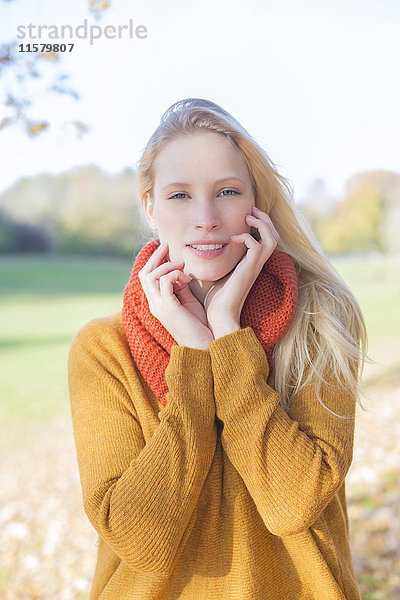 Porträt einer hübschen blonden Frau im Park im Herbst