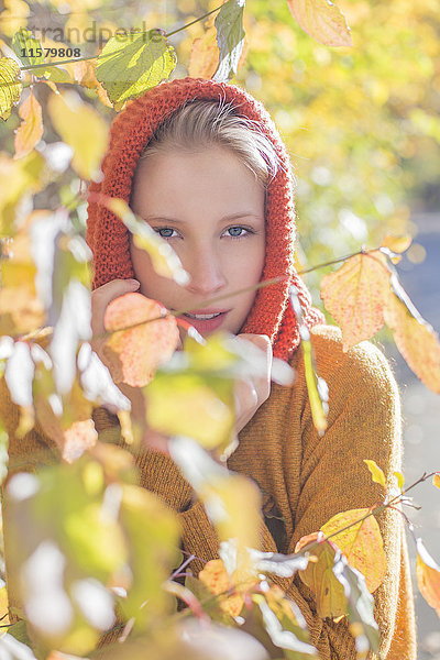 Porträt einer hübschen blonden Frau im Park im Herbst mit Blättern
