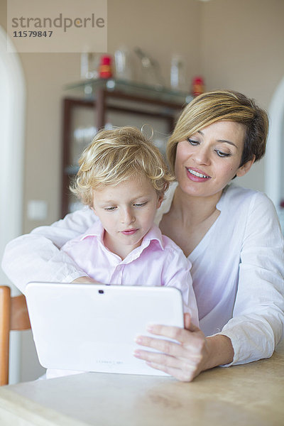 Frau und Sohn mit digitalem Tablett zu Hause