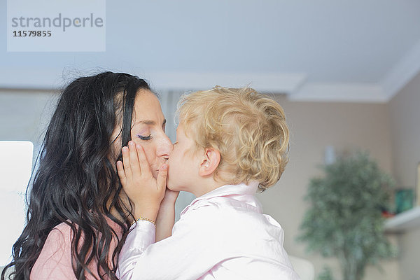 Süßer kleiner Junge  der seine Mutter küsst.