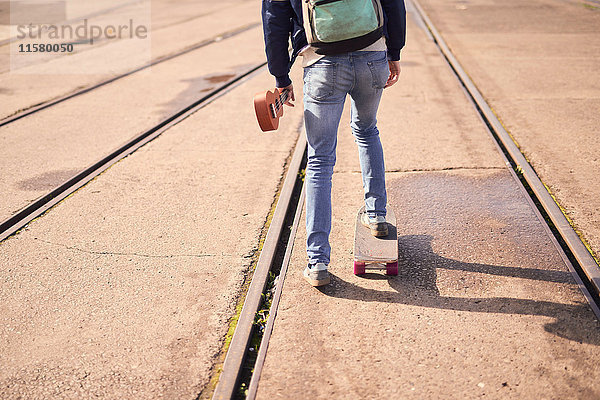 Junger Mann fährt Skateboard zwischen den Fahrgassen  Rückansicht  niedriger Abschnitt  Bristol  UK