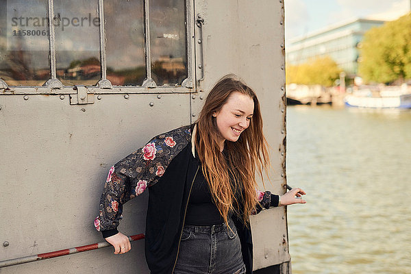 Junge Frau beim Herumalbern am Fluss  Bristol  UK