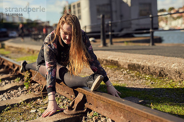 Junge Frau beim Spagat  Balancieren auf Zuggleisen  Bristol  UK