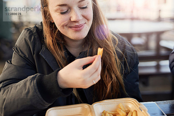 Porträt einer jungen Frau  im Freien  Chips essend  Bristol  UK