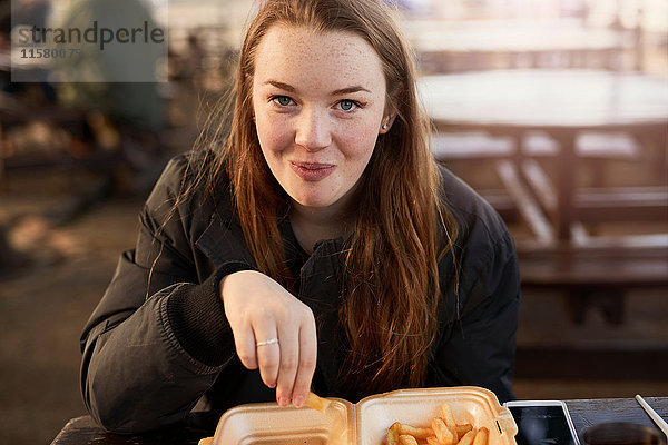 Porträt einer jungen Frau  im Freien  Chips essend  Bristol  UK