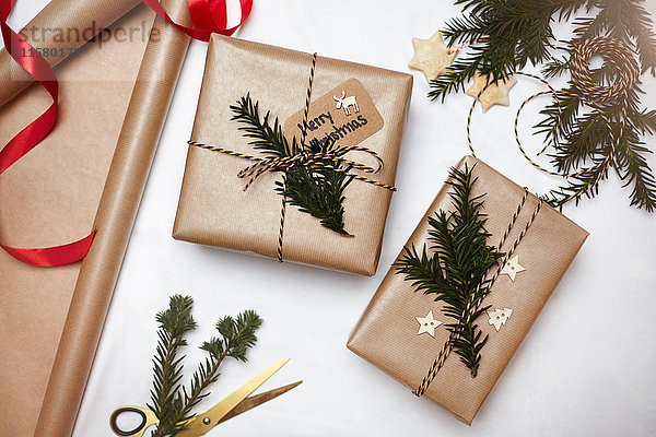 Weihnachtsgeschenke in braunes Papier gewickelt  mit Farn und Schnur dekoriert  Draufsicht