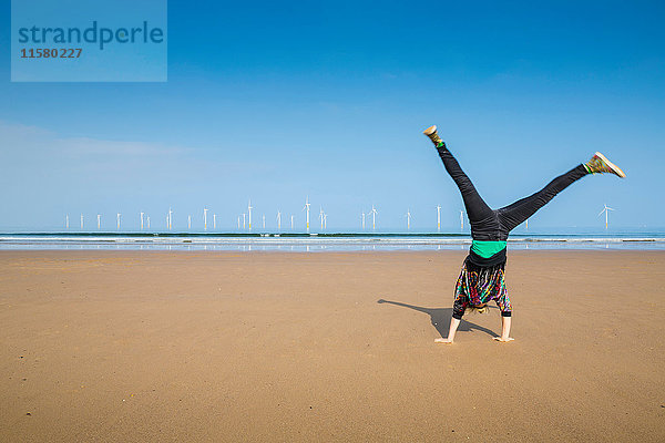 Ältere Frau beim Radschlagen am Strand von Redcar  North Yorkshire  UK