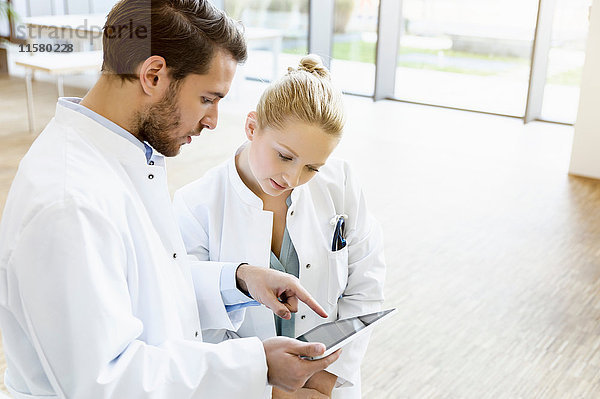 Zwei Ärzte sehen sich digitales Tablett an