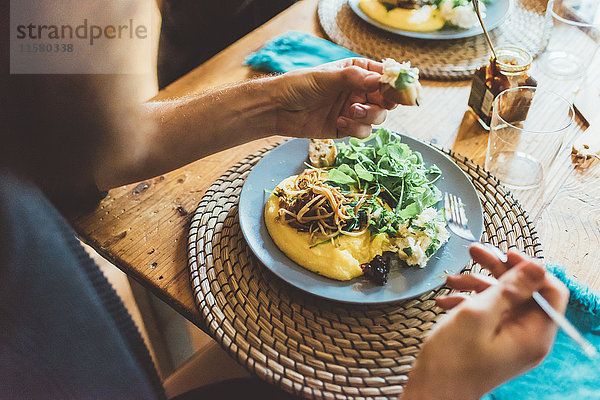 Über-Schulter-Ansicht eines Mannes beim Omelettessen am Tisch
