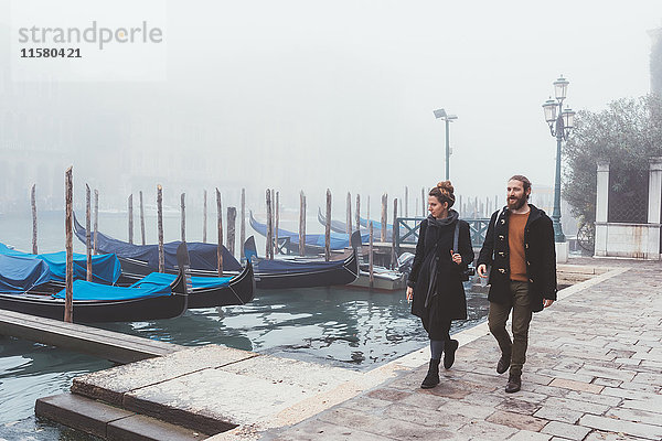 Paar beim Spaziergang entlang des nebligen Kanalufers  Venedig  Italien