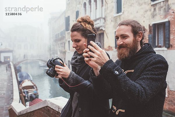 Fotografisches Paar am Ufer des nebligen Kanals  Venedig  Italien